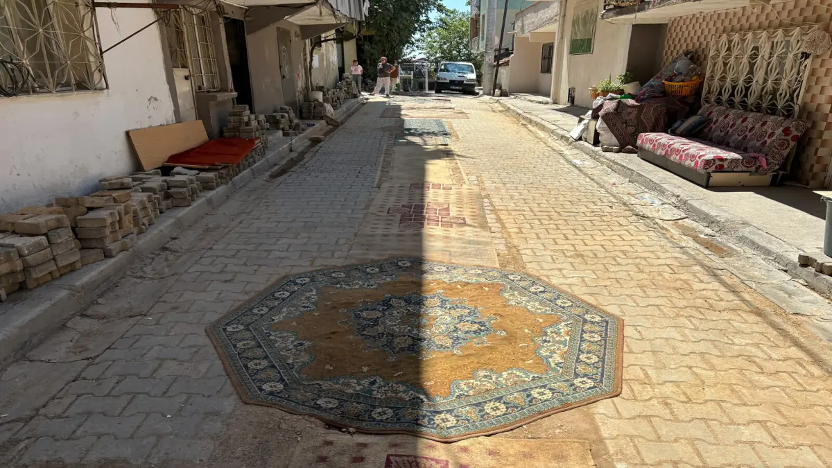İzmir'de bir mahalle tozdan korunmak için yollara halı serdi